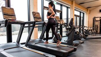 A gym with treadmills, exercise bikes, and weight machines.