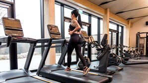 Un gimnasio con cintas de correr, bicicletas estáticas y máquinas de pesas.
