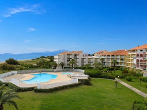 Un resort con piscina, edificios de varios pisos y vista al mar.