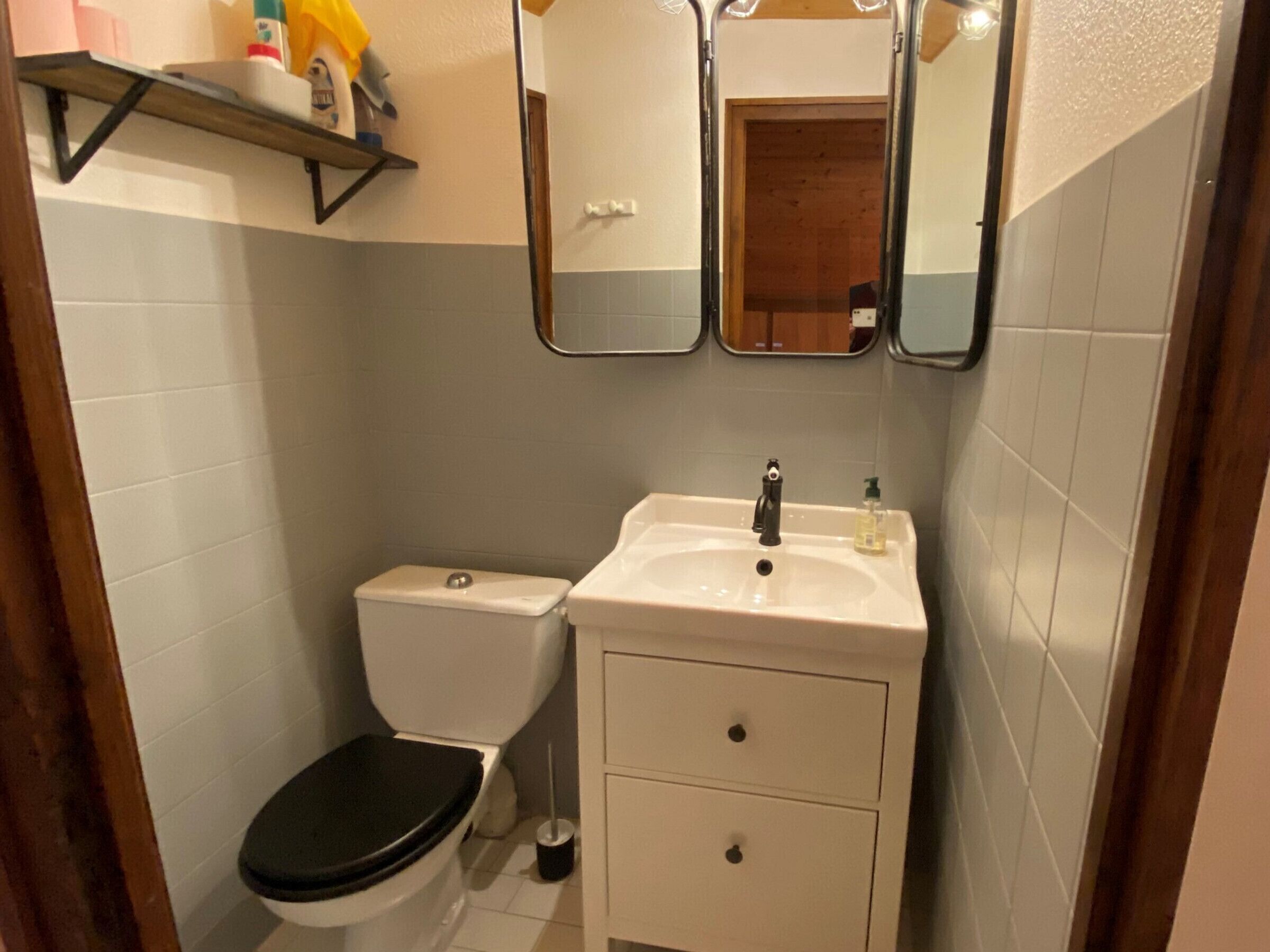 Ein kleines Badezimmer mit Toilette, Waschbecken und Spiegel.