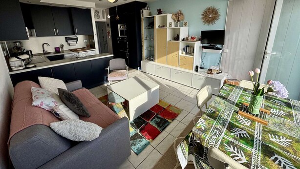 A modern apartment with a kitchen, dining area, and living room.