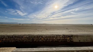 A beach with a stone wall in the foreground.
