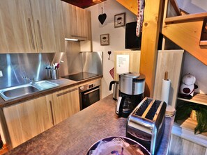 A modern kitchen with stainless steel appliances, wooden cabinets, and a built-in toaster.