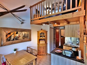 Eine gemütliche Küche mit Holzausstattung, einem Esstisch und einem Deckenventilator.