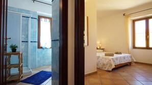A bedroom with a bed, bedside table, and a window.