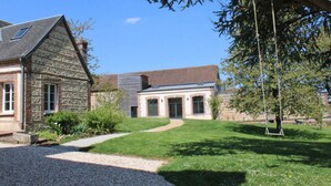 A building with a stone facade, a sloped roof, and a gravel driveway.