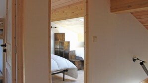 Une chambre à coucher avec un lit, une table de chevet et un plafond en bois.