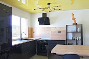 A compact kitchen with a sink, stove, and wooden cabinets.