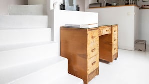 A staircase leading to a kitchen area with a white countertop and wooden drawers. - White House, by Veeve (Paris)
