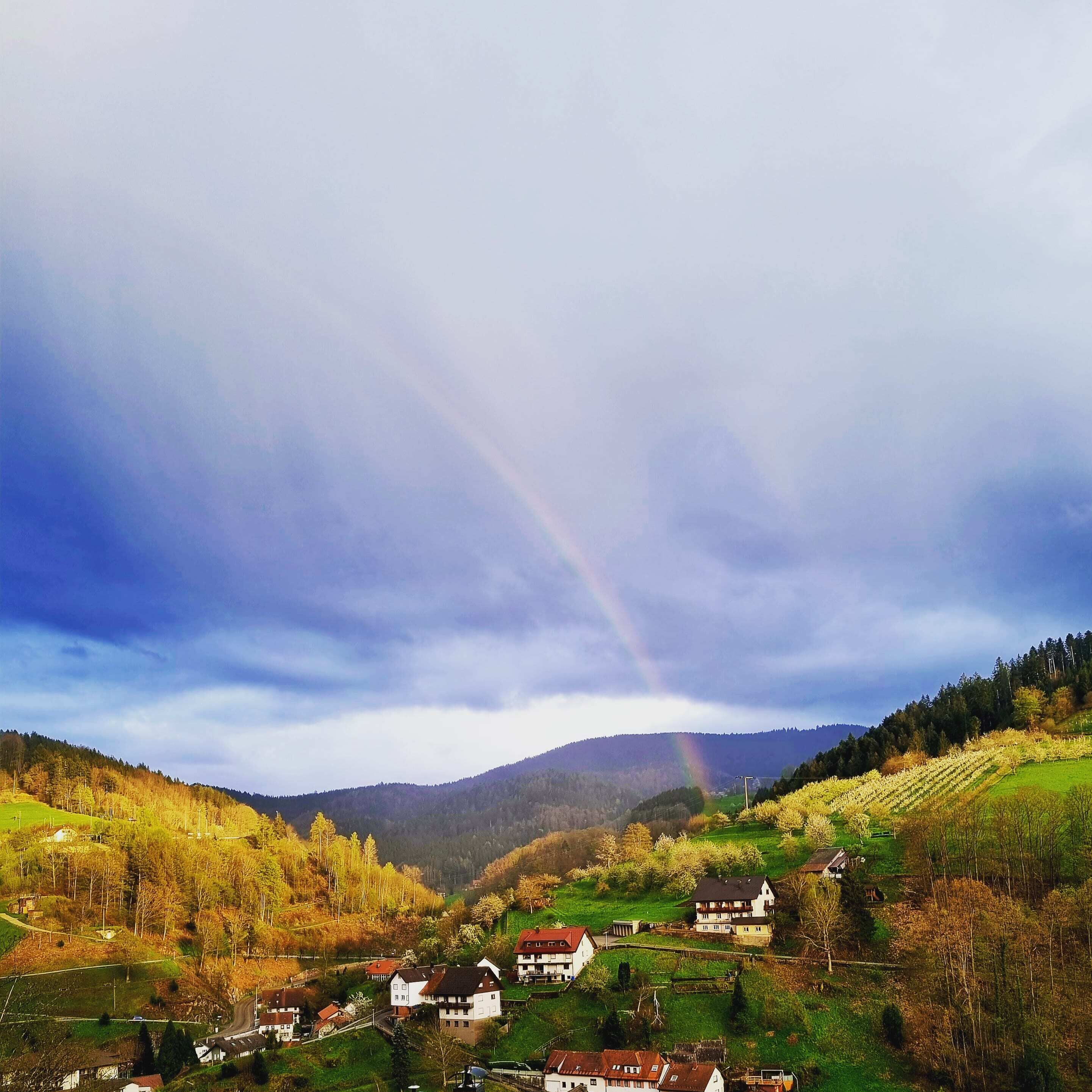 Un paisaje rural con casas y una montaña al fondo.
