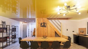 Eine moderne Küche mit einem Holztisch, schwarzen Stühlen und einer Treppe, die zu einer anderen Ebene führt.