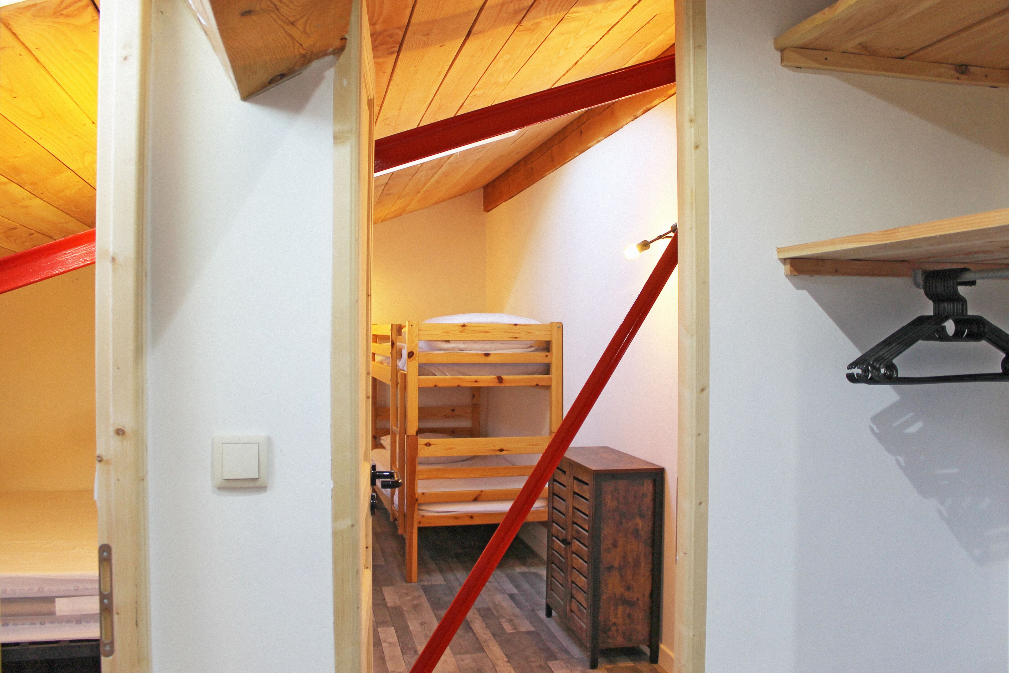 Ein schmaler Gang mit Holzwetterbett und kleinem Schminktisch.