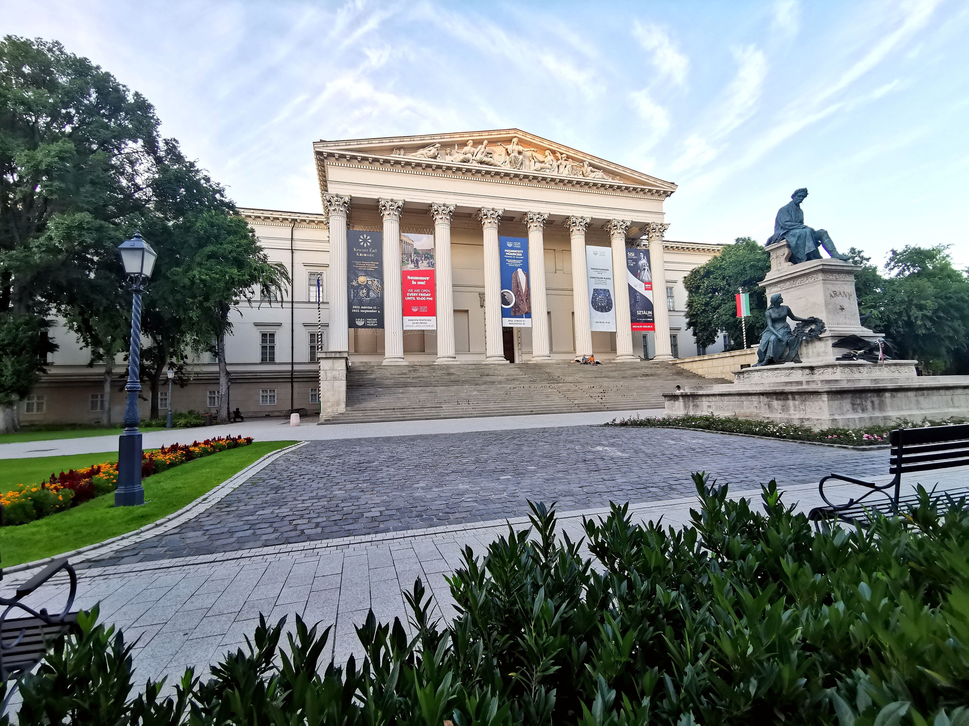 A grand building with classical architecture, featuring columns and a central statue.