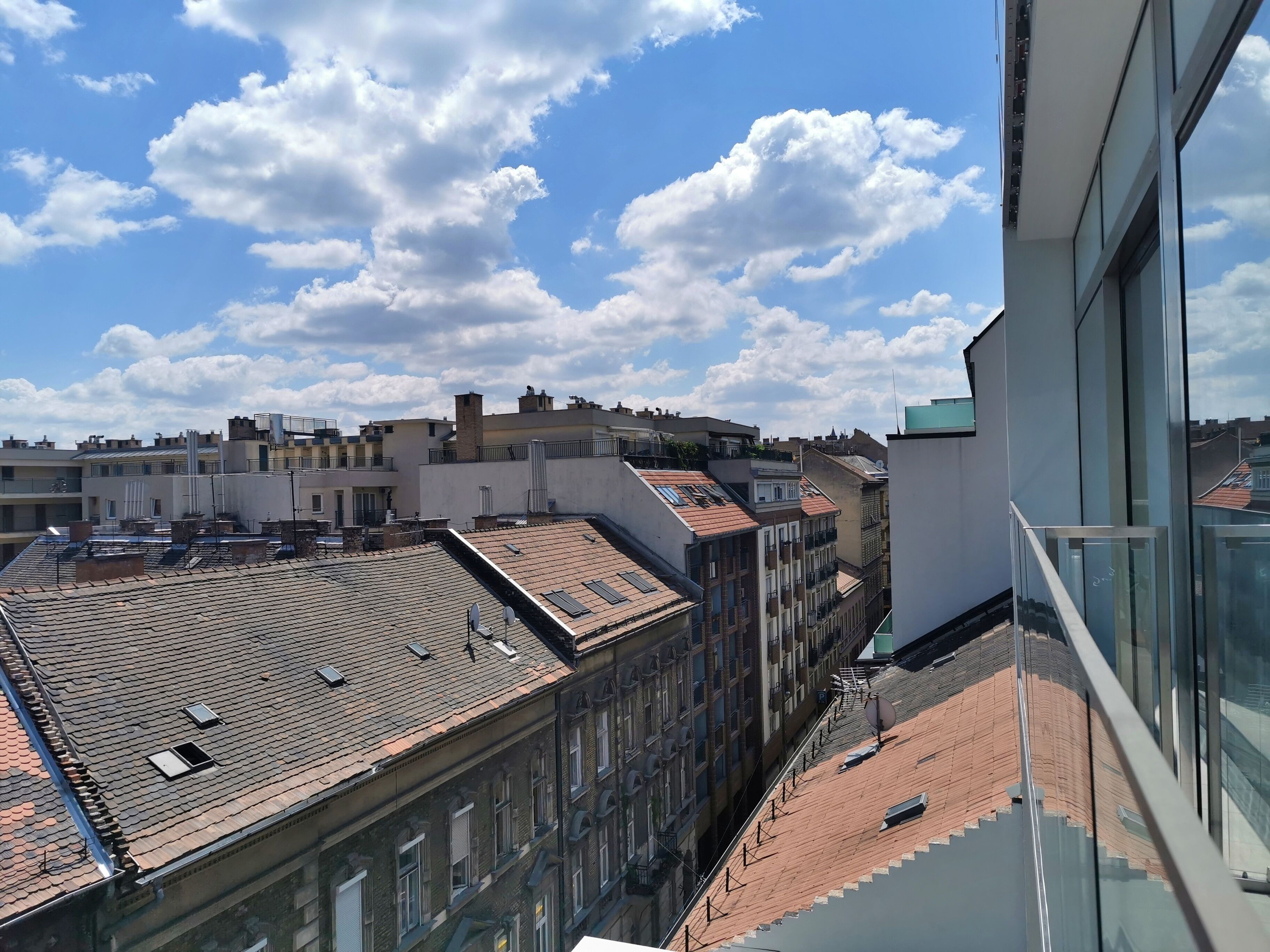 A view of a cityscape with multiple buildings, some with flat roofs and others with sloped roofs.