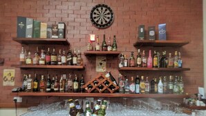 A bar area with shelves of liquor bottles, a dartboard, and a bucket labeled "SMIRNOFF ICE". - The Nelion (Naro Moru)