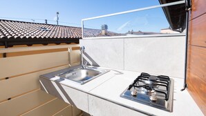 Une cuisine de taille réduite, équipée d’un évier, d’une cuisinière et de meubles de rangement en bois.