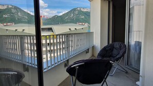 A balcony with a view of mountains, a chair, and a glass door. - Le petit marquisat à deux pas du lac (Annecy)