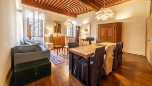 Amplia sala de estar con techo de madera, una mesa de comedor con sillas, un sofá y un armario.