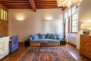 A cozy living room with a light blue sofa, a wooden coffee table, and a patterned rug. - Le Rousseau Charming apartment old town (Annecy)