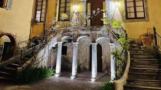 Un edificio histórico con una escalera central, varios balcones y un patio.