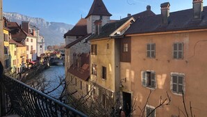 Un río con edificios a un lado y una montaña al fondo.