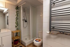 Een douche, handdoeken, zeep, toiletpapier