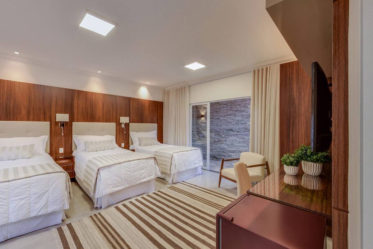 Une chambre d’hôtel moderne équipée de deux lits, d’un bureau, d’une chaise et d’un téléviseur.