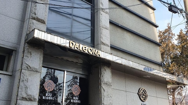 A building with a sign reading "DAIGONA" and a logo indicating it's a guest house. - Dalgona Guesthouse (Seoul)