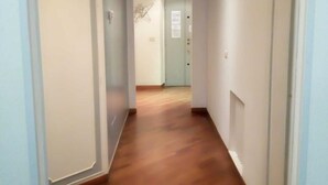 A narrow hallway with wooden flooring and white walls. - Large Vatican Apartment with 3 bedroom (Rome)