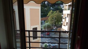 A view from a balcony with a metal railing, a parking lot, and buildings in the background. - Large Vatican Apartment with 3 bedroom (Rome)