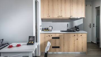 A modern kitchen with wooden cabinets, a white countertop, and a dining area with a table and chairs.