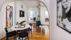 Ein moderner Essbereich mit einem runden Tisch, schwarzen Stühlen und einer weißen Wand mit einer Uhr.