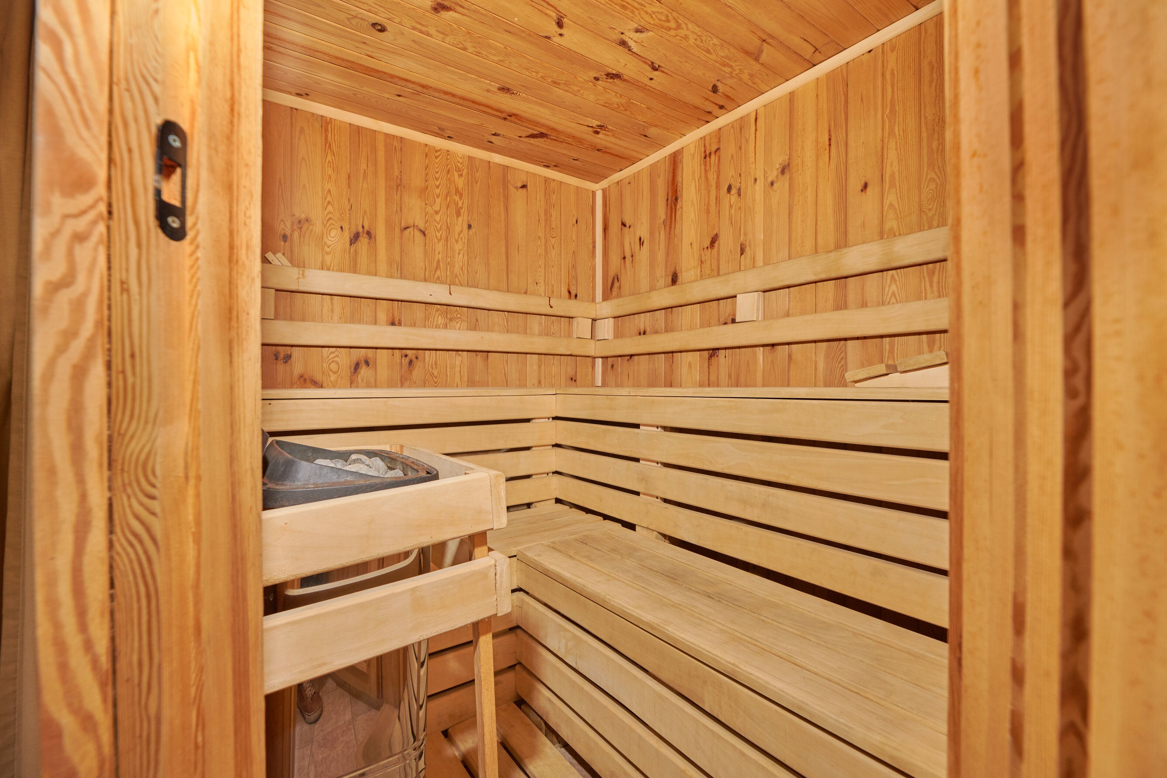 Una sauna con bancos de madera y un banco con toalla.