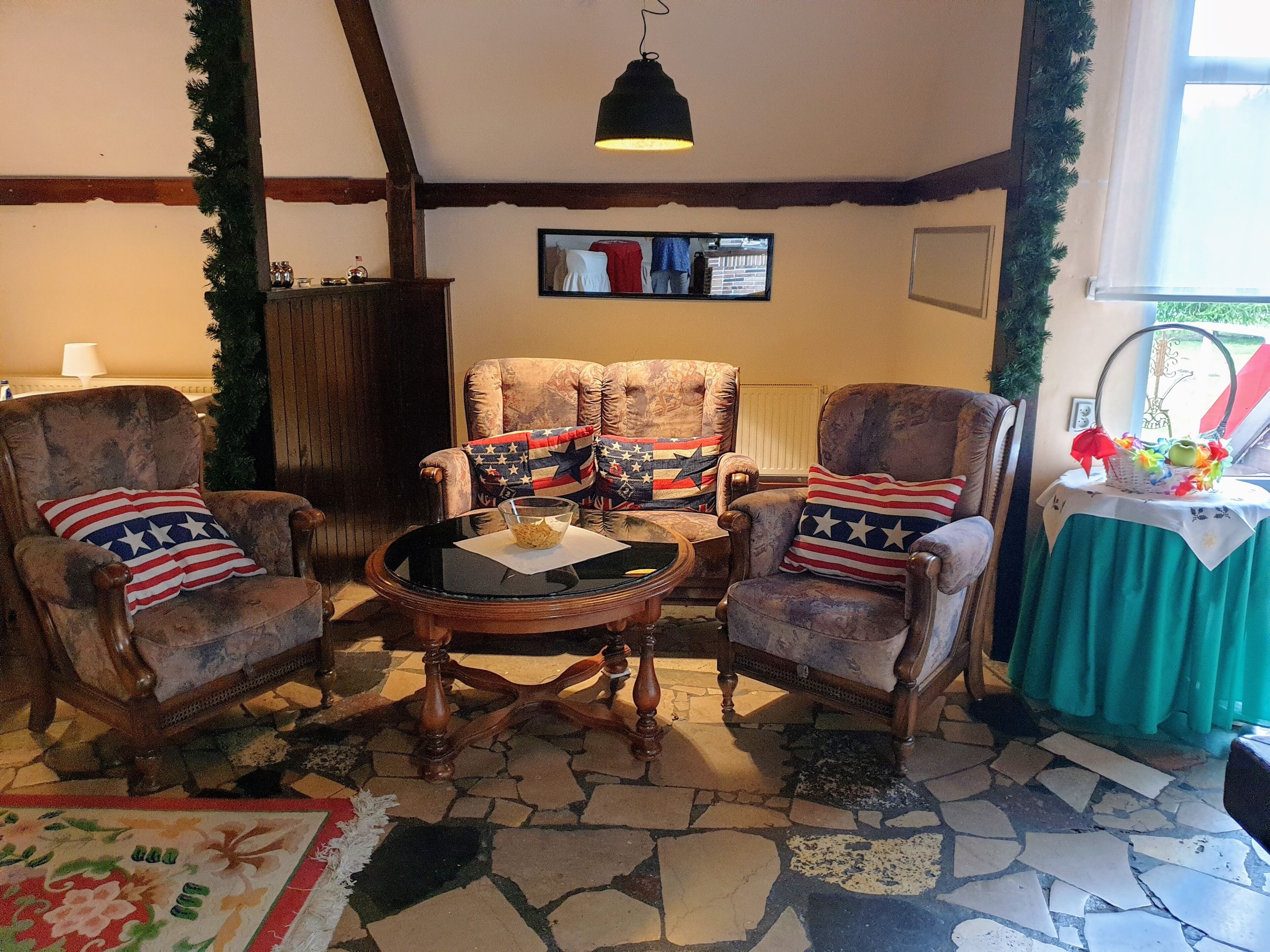 A cozy room with two armchairs, a small table, and a television on the wall.