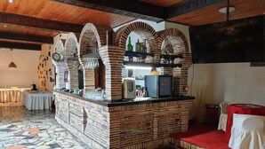 A bar area with brick arches, a tiled floor, and a red carpeted area. - Park Inn Resort (Miroslawiec)