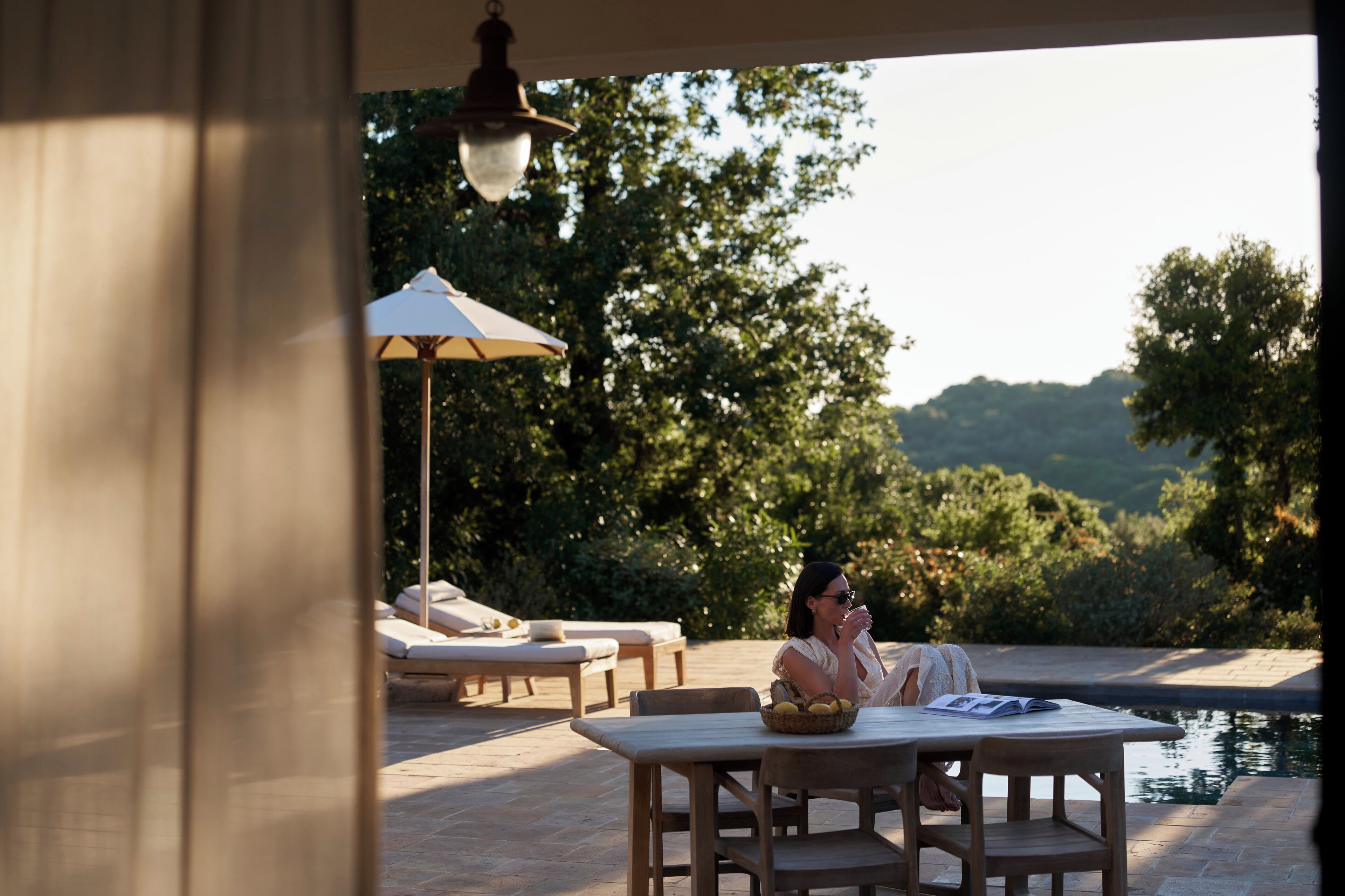 A patio area with a table, chairs, and a lounge chair.