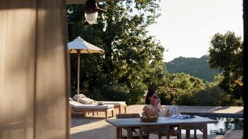 A patio area with a table, chairs, and a lounge chair.