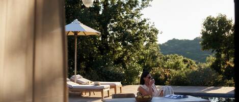 A patio area with a table, chairs, and a lounge chair.