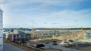 A modern building complex with multiple parking areas and a clear sky.
