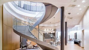 A modern interior with a spiral staircase, wooden flooring, and contemporary furniture. - Radisson RED Hotel, Oslo Airport (Ullensaker)