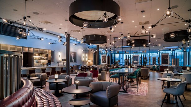 A modern lounge area with leather seating, round tables, and pendant lighting. - Radisson RED Hotel, Oslo Airport (Ullensaker)