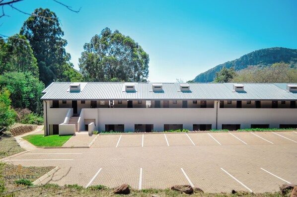A modern building with a flat roof, multiple windows, and a parking lot. - Avoca Vale Country Hotel (Louis Trichardt)