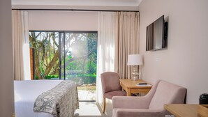Una habitación de hotel con una cama, un escritorio, una silla y un televisor.