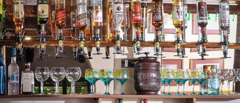 Un bar avec différentes bouteilles de spiritueux et des verres.