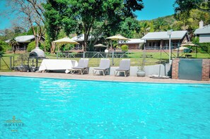 A pool area with lounge chairs and a barbecue grill. - Avoca Vale Country Hotel (Louis Trichardt)