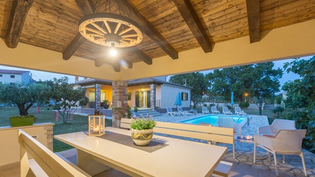 An outdoor patio with a wooden table, benches, and a lantern. - Villa with pool, 6 persons, large garden with barbecue. Dogs are welcome! (Sv. Lovrec)