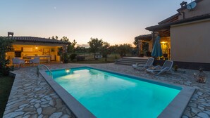 A swimming pool with stone tiles, lounge chairs, and a patio area with a table and chairs. - Villa with pool, 6 persons, large garden with barbecue. Dogs are welcome! (Sv. Lovrec)