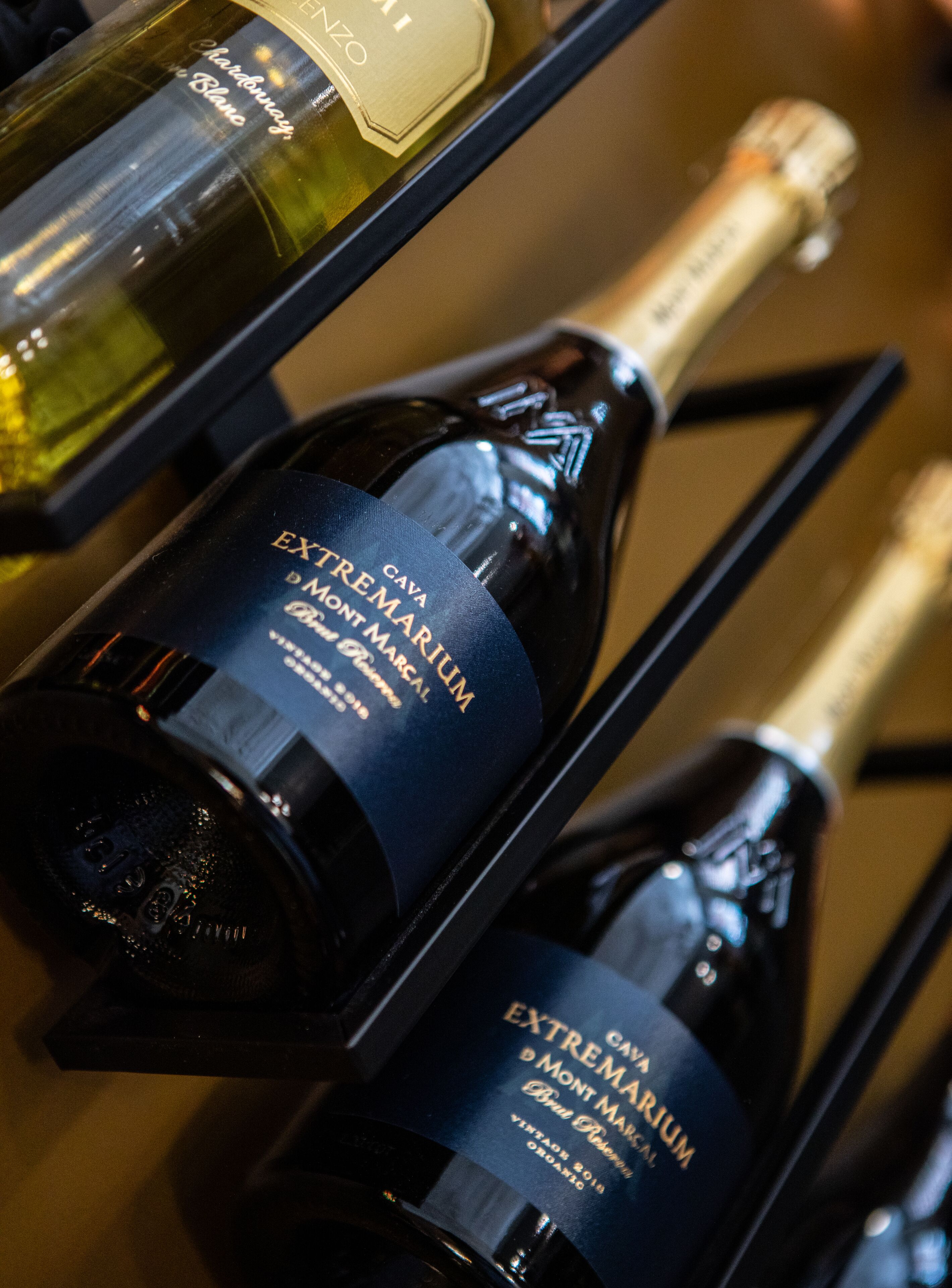 Two bottles of Cava Montmarc, a vintage 2019 organic wine, displayed on a wooden surface.