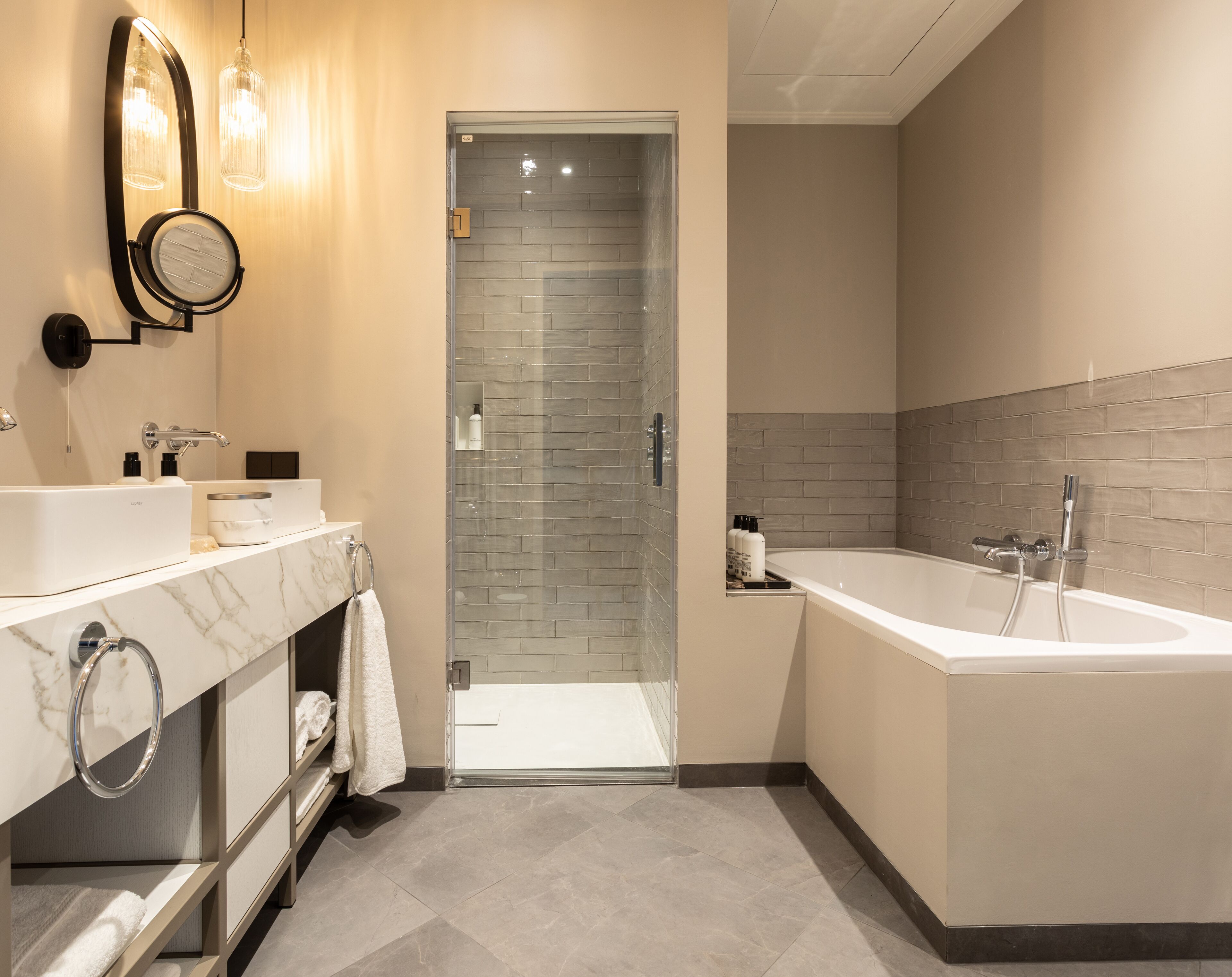Luxe tweepersoonskamer | Badkamer | Een regendouche, gratis toiletartikelen, een haardroger, handdoeken