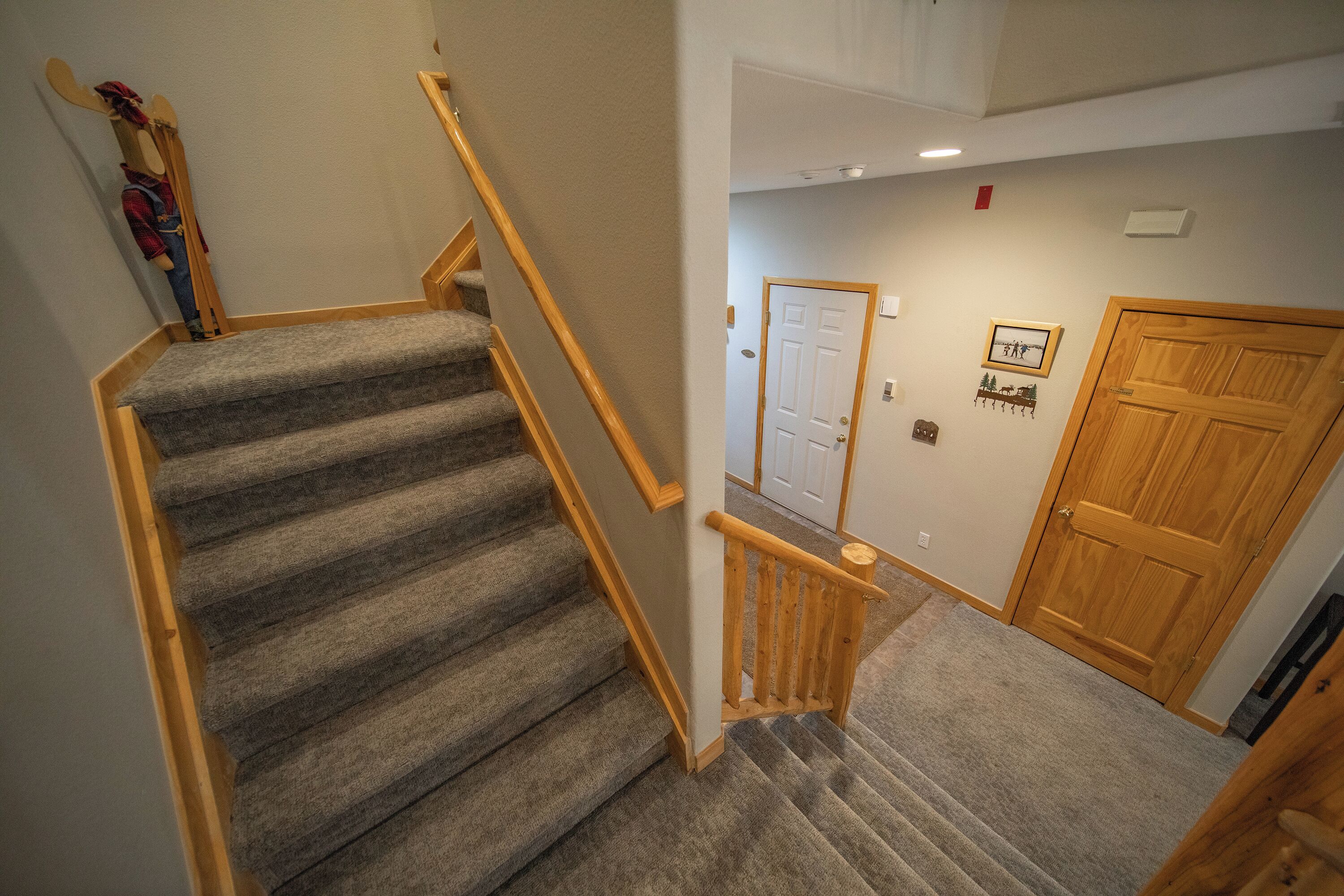 A carpeted staircase with wooden handrails leading to a landing.